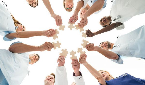Menschen stehen in einem kreis mit einem Puzzelteil in der Hand